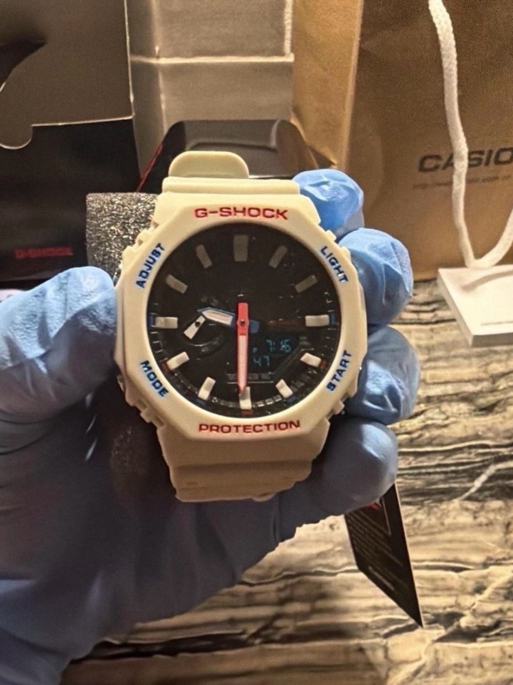 G-Shock White Bezel Black Dial Watch with Red and Blue Accents text 5045474637